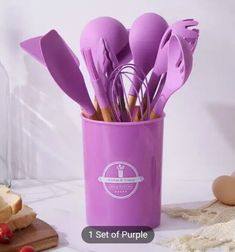 purple utensils sitting in a purple cup with spoons sticking out of it