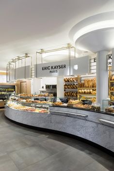 the interior of a bakery with many different types of breads and pastries on display