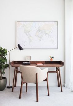 a desk with a chair and a map on the wall