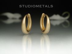 Elegant and simple matte 14K gold huggie hoop earrings, 12mm in diameter. Comfortable and made to last a lifetime, these huggies are perfect to wear everyday, 24/7. Shower in them, sleep in them, go anywhere and everywhere! A thoughtful, high quality gift for him or for her. * Handmade in solid 14K yellow, white or rose gold. * Outside diameter of 12mm. * Inside diameter of 8.5mm. * The bottom width is 3mm and tapers toward the top to a standard size ear wire. * Approximate weight of 2.6 grams for the pair in 14K gold. * Available in a matte or polished finish. Please allow us about 2 weeks to make your earrings prior to shipping. We ship FedEx Ground or Canada Post Xpresspost with tracking and a signature required for delivery. Shipping upgrades available at checkout. The video and photos Matte Gold Earrings, Gold Huggie Hoop Earrings, Gold Huggie Earrings, Gold Alloys, Huggie Earrings, Canada Post, Huggie Hoop Earrings, Jewelry Earrings Hoops, Leave In