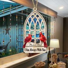 a stained glass window with two red birds hanging from it's side and the words, i am always with you