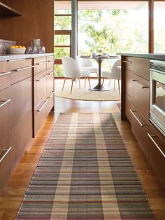 a kitchen with wooden cabinets and an area rug on the floor