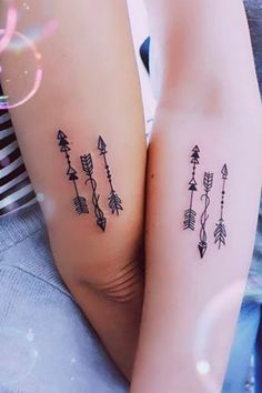 two people with tattoos on their arms, one has an arrow and the other has arrows