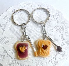 two peanut butter and jelly sandwich shaped keychains on a doily with lace