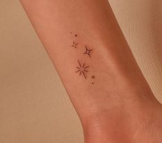 a small star tattoo on the left ankle is shown in black ink, and has three stars above it