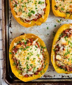 four stuffed bell peppers on a baking sheet with cheese and parmesan toppings