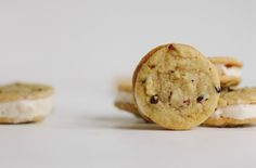 three cookies with white cream and chocolate chips are arranged next to each other on a table