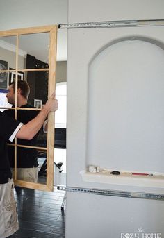 a man standing in front of a mirror holding onto the door frame with his hands