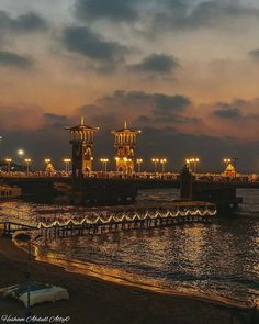 the pier is lit up at night with lights on it