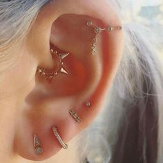 a woman wearing gold ear piercings with diamonds