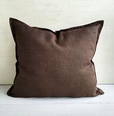 a brown pillow sitting on top of a white floor