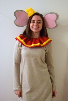 a woman standing in front of a wall wearing a mouse costume