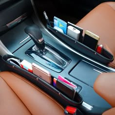 the interior of a car with cell phones and other items in its storage trays