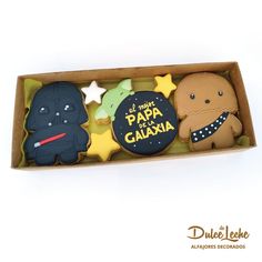 three decorated cookies in a cardboard box on a white surface with the words papa de cauaxa