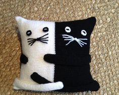 a black and white cat pillow sitting on top of a rug