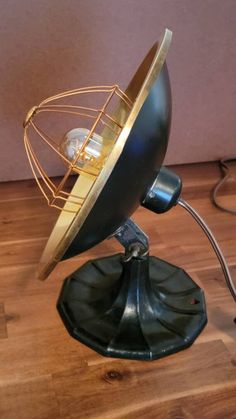 a black and gold metal object sitting on top of a wooden floor