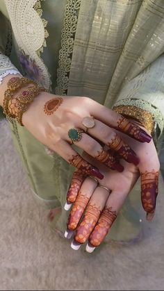 a woman's hands with hennap and rings on them