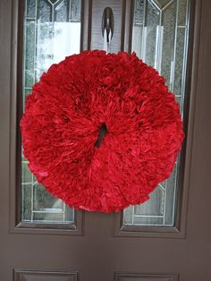 a red wreath hanging on the front door