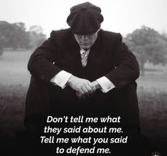 a man in a suit and tie sitting down with his hands folded over his knees