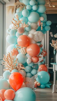 the balloon columns are decorated with coral, blue and orange balloons for an understated look