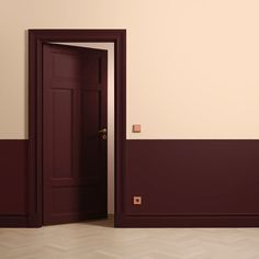 an open door in a room with red walls and parquet flooring on the side