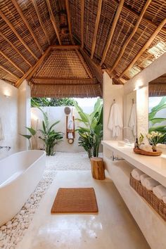 a bathroom with a large white bathtub next to a walk in shower under a thatched roof