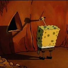 the spongebob is standing in front of a cave