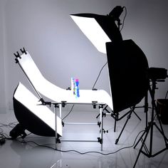 the lighting equipment is set up in front of an empty table with pens on it