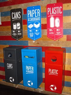 several recycling bins are lined up on the wall