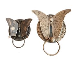 two metal butterfly shaped bottle openers with rings