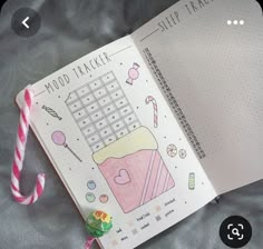 an open planner book with candy canes and candies on the cover, next to a pink striped lollipop