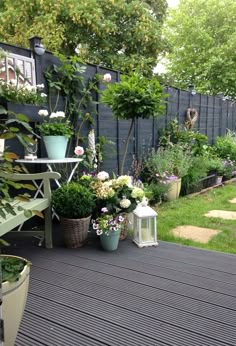 an outdoor deck with potted plants and flowers