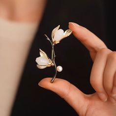 Why We Made This Crafted with meticulous attention to detail, this stunning piece captures the delicate beauty of magnolia blossoms in full bloom. Symbolizing beauty, grace, and resilience, the magnolia flower serves as a timeless emblem of strength and femininity. Wear this brooch as a reminder of your own inner beauty and the power of resilience. Product Details MADE FROM Brass, Zircon, Freshwater Pearl, Serpentine MEASUREMENTS Brooch size : 45 x 60mm / 1.8'' x 2.4'' TURN AROUND 2-3 days CARE