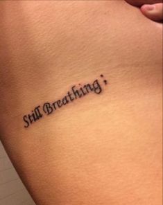 a woman's stomach with the words still breathing written in cursive font