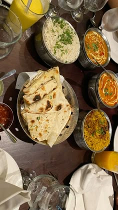 a table filled with lots of different types of food on plates and glasses next to each other