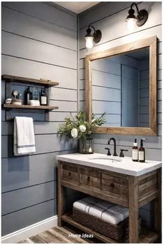 a bathroom with gray walls and wood accents, including a large mirror above the sink