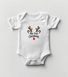 Celebrate your little one's first Christmas with our adorable "My First Christmas" reindeer bodysuit! Featuring a sweet reindeer design complete with antlers and a bright red nose, this bodysuit is perfect for capturing precious holiday moments and making festive family memories. Crafted from 100% soft, breathable cotton, this bodysuit ensures your baby stays cozy and comfortable all day. The charming reindeer print adds a playful touch to holiday outfits, while the easy snap closures make diape Christmas Baby Clothes, Christmas Babygrow, My First Christmas Outfit, Christmas Bodysuit, Baby Overall, Newborn Blankets, Personalized Newborn, My First Christmas, Baby Christmas Outfit