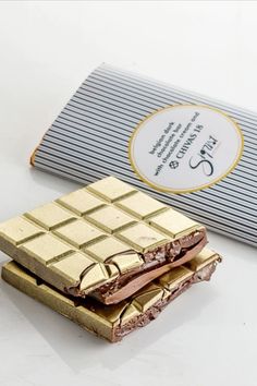 two pieces of chocolate sitting on top of each other next to a bar of chocolate