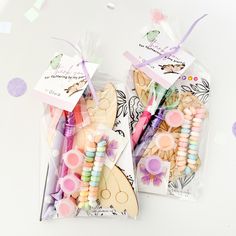 two bags filled with wooden bead toys on top of a white table next to confetti