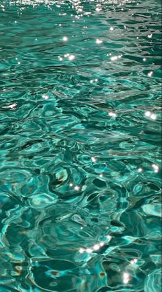 the water is crystal blue and has ripples on it's surface, as well as bubbles in the water