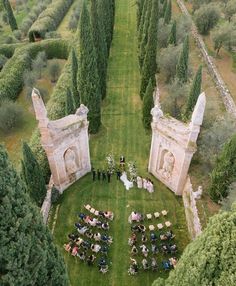 an aerial view of a wedding ceremony in the middle of a field with trees around it