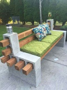 a bench made out of concrete blocks with green cushions