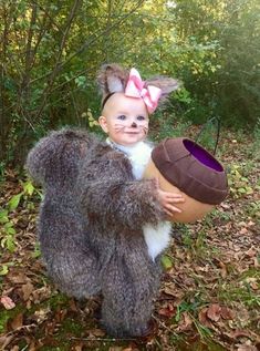 a baby dressed as a bear holding an easter egg