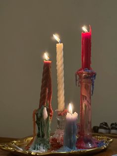 three candles are lit on a tray with other items