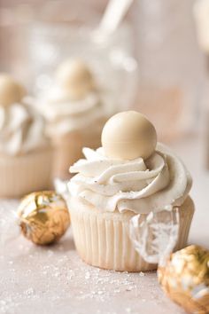 cupcakes with white frosting and gold decorations