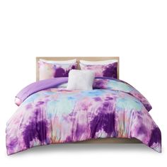 a bed with purple and blue comforters on it