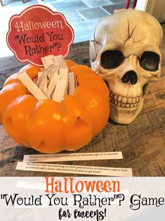 a skull sitting on top of a wooden table next to a halloween sign and a pumpkin