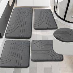 four bathroom mats on the floor in front of a sink