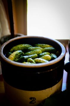 a pot filled with pickles sitting on top of a table