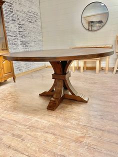 a wooden table sitting on top of a hard wood floor next to a dresser and mirror